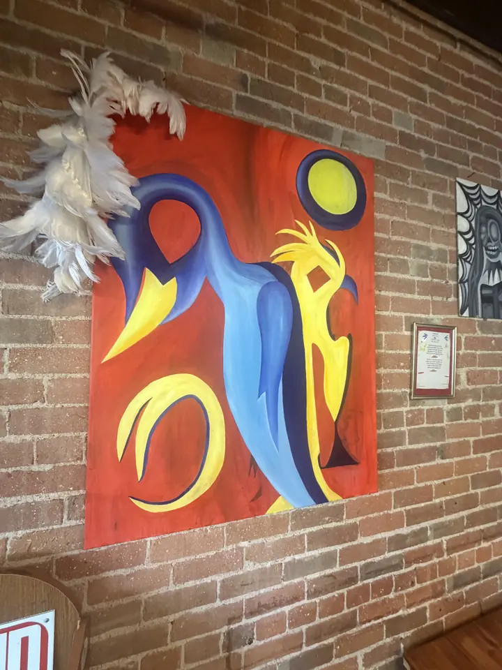Abstract canvas by Arely Ahidali in orange, blue and yellow on the brick wall at Spotlight Café