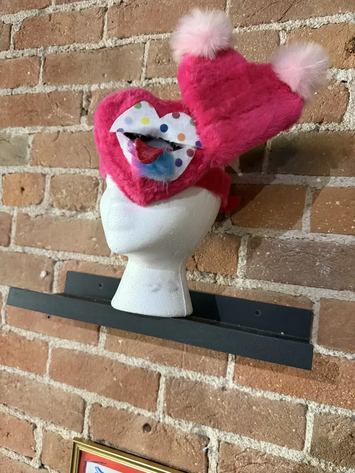 Love Blind (Amor Ciego), a pink faux fur wearable sculpture with a polka dot eyepatch, by Arely Ahidali